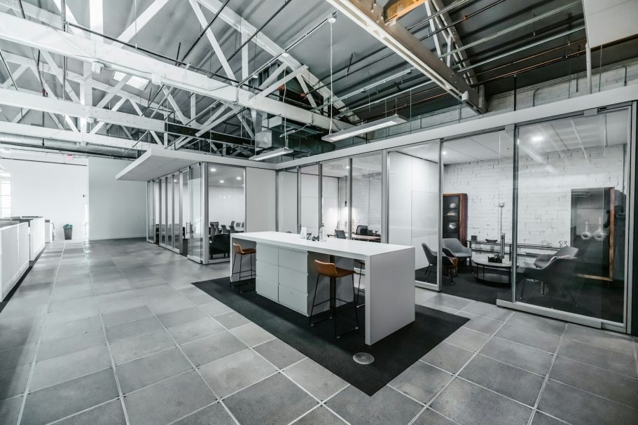 Moderne Büroumgebung mit gläsernem Besprechungsraum und heller, offener Fläche.